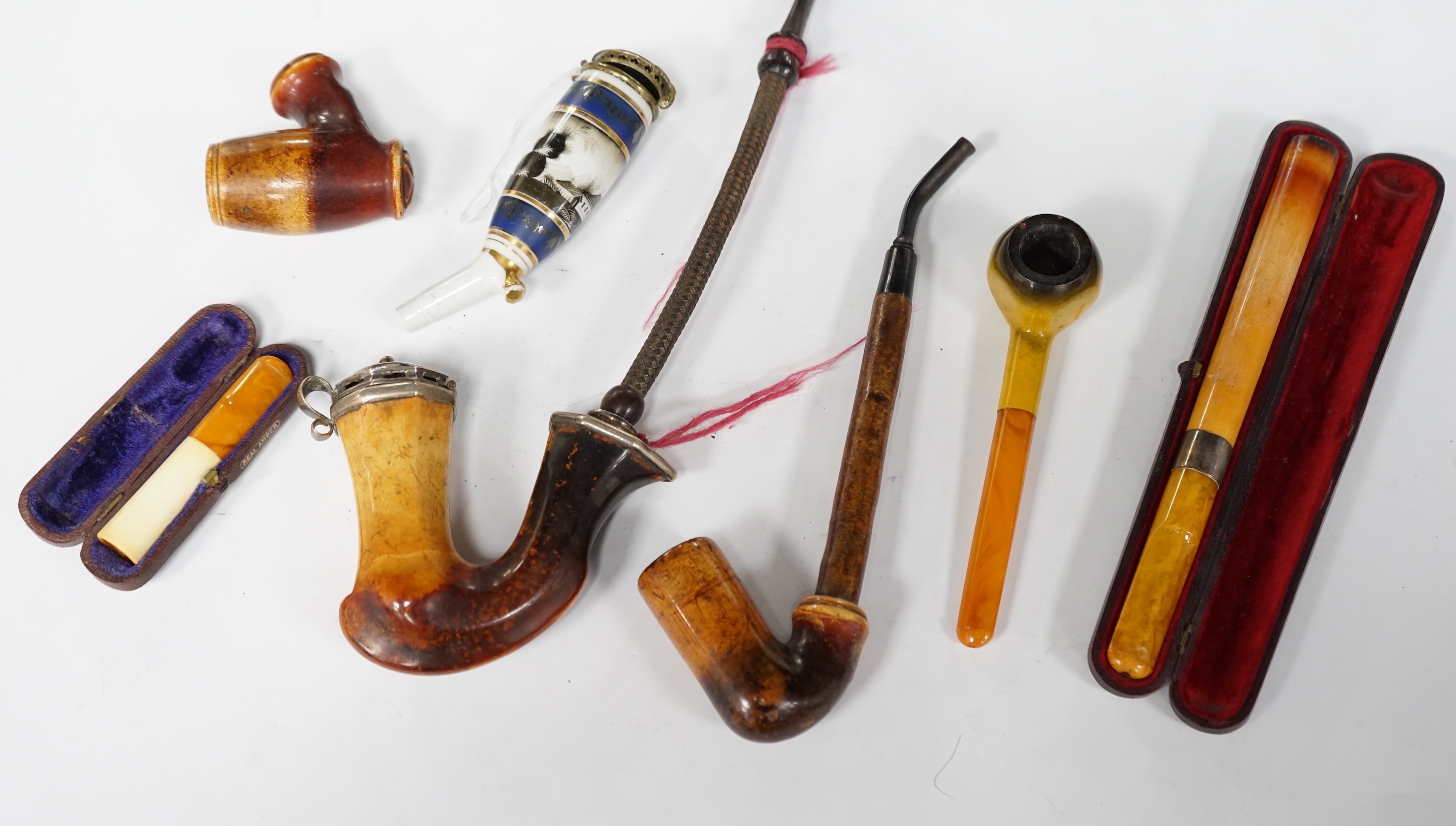 Seven pipes, three with amber mouthpieces, two cased and two without mouthpieces, longest cased pipe 20cm long